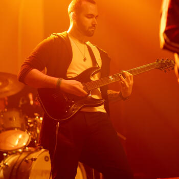 A band member playing the electric guitar.