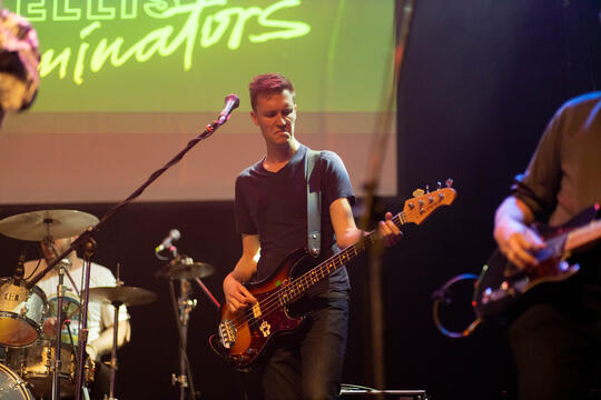 A man playing the electric guitar on stage.