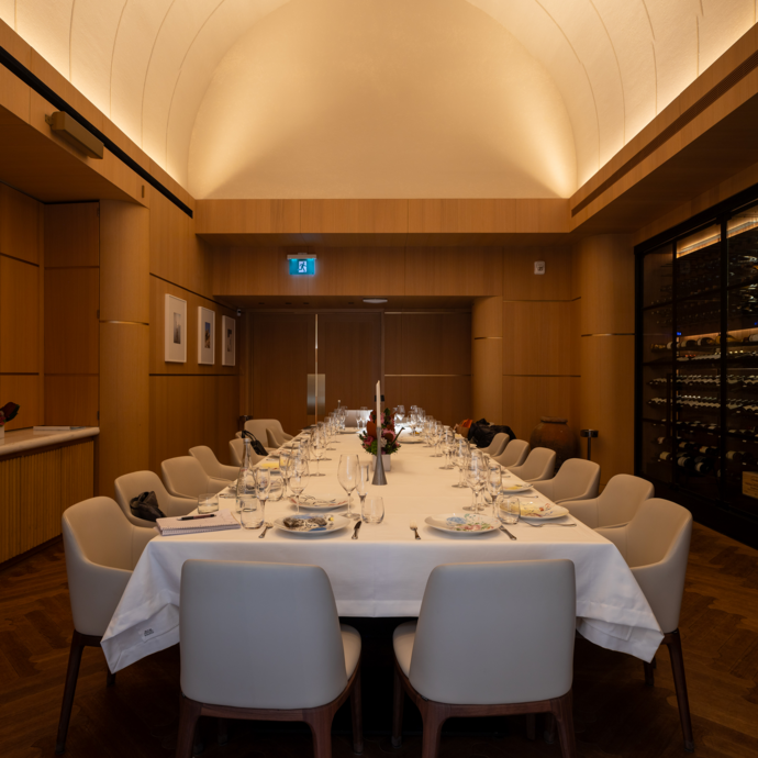 Photo of a private dining room with a wine cellar and table for 20 people.