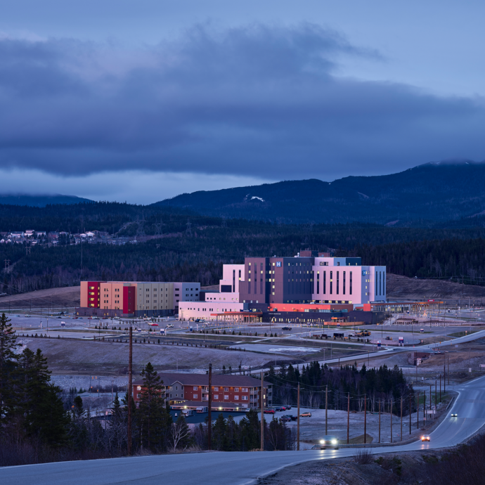 Far away nighttime image of New Western Regional Memorial Hospital from up a hill.