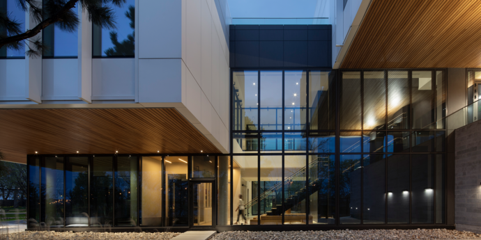 Night shot of the external building with windows and exposed wood features.